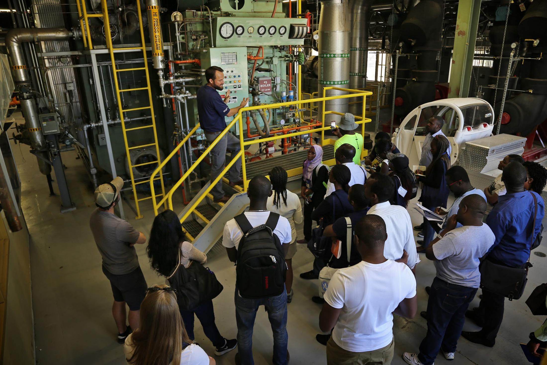 Joshua Moorejohn showing a boiler on a facilities tour