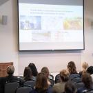 Camille Kirk speaks from a podium in front of a crowd of UC Davis students